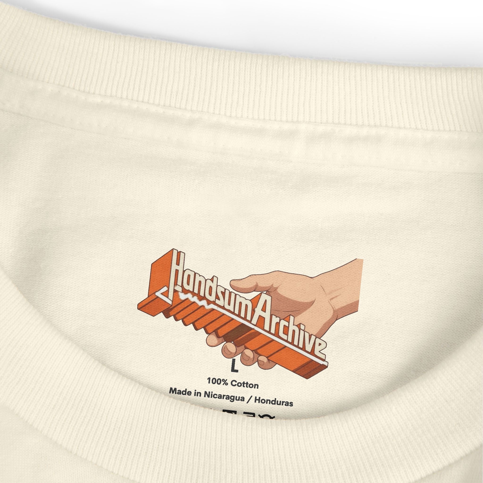 Close-up of cream tee hem label with “100% Cotton” and “Made in Nicaragua” text.