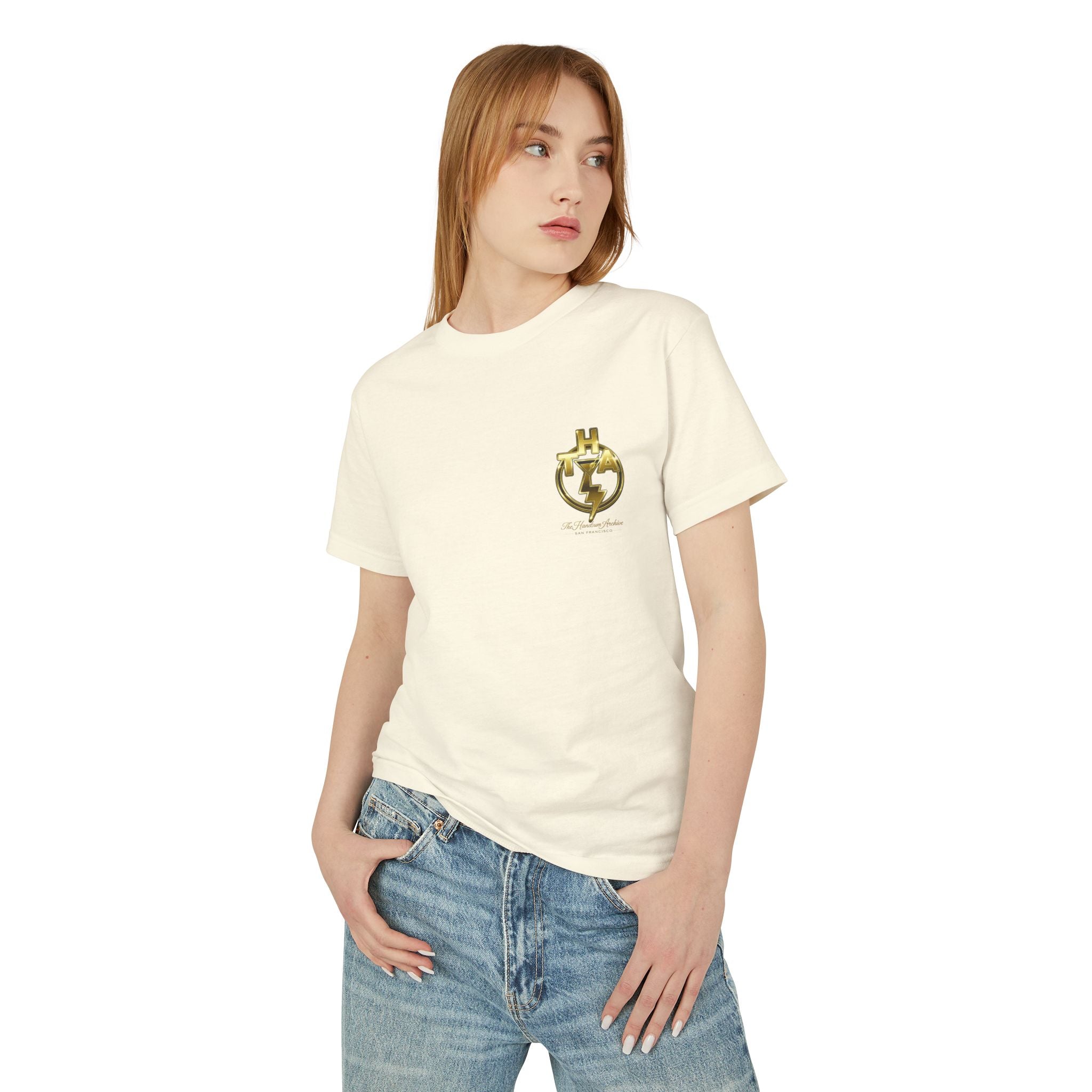 Faded cream short-sleeve graphic T-shirt on model with gold chest emblem