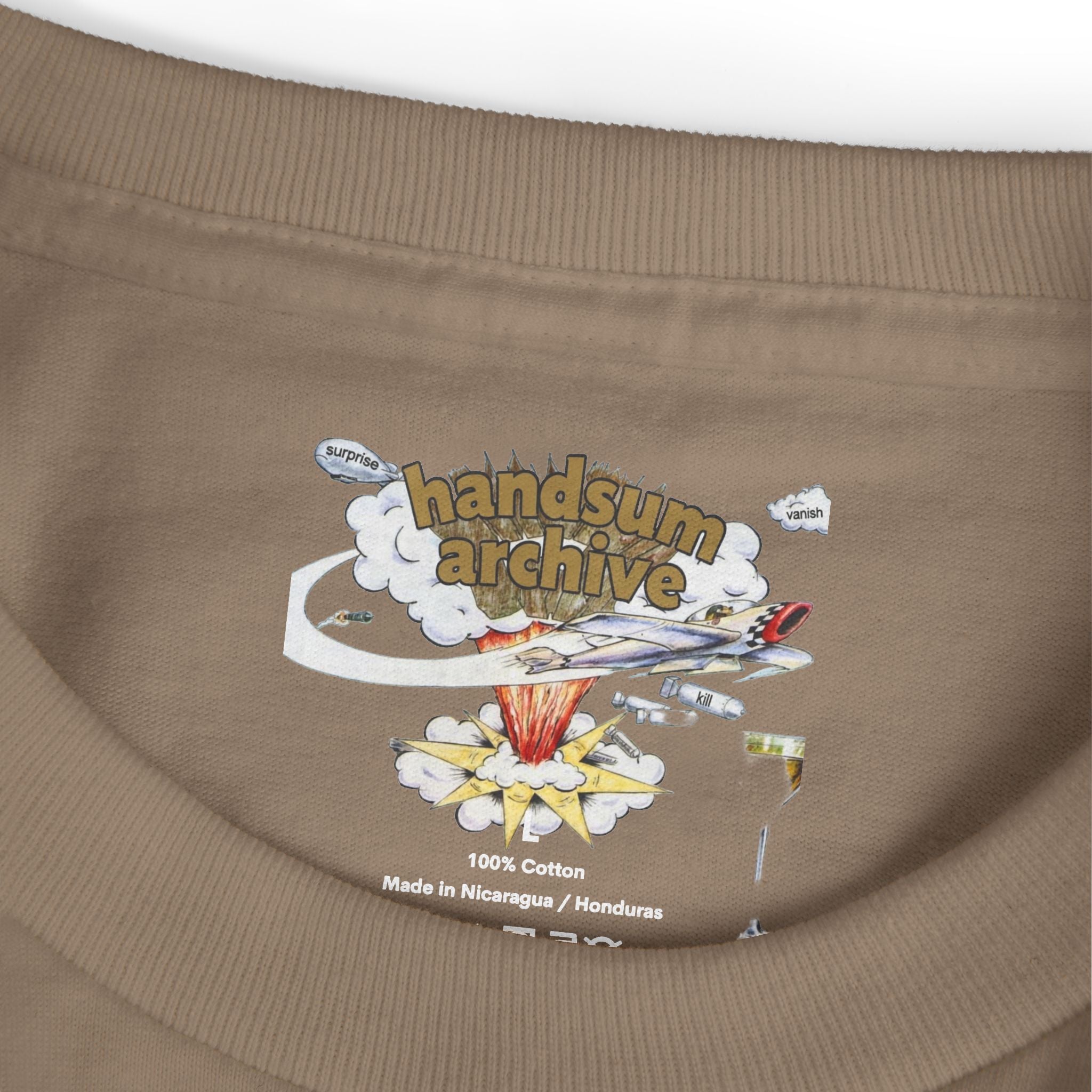 Brown tee hem close-up with “100% Cotton” and “Handsum Archive” print.