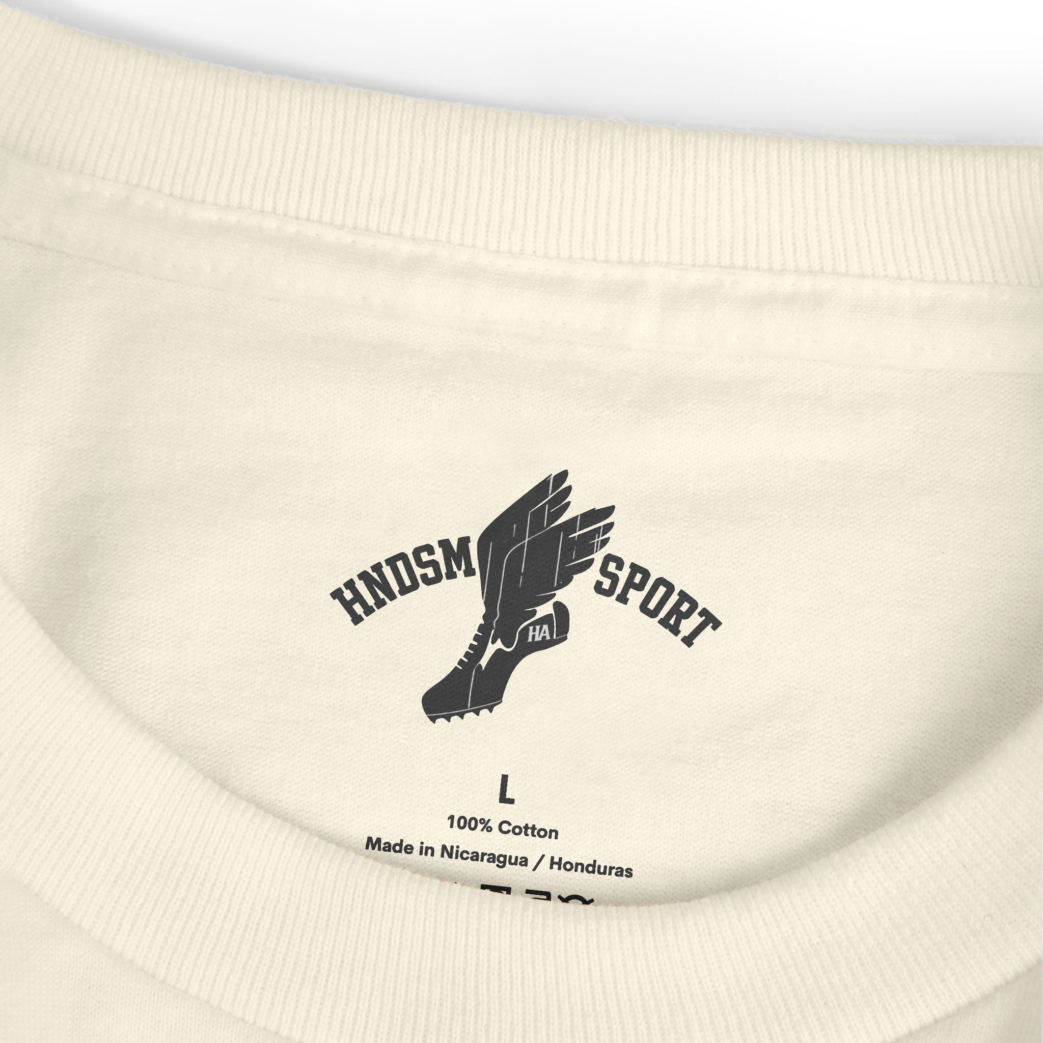 Cream tee close-up of ribbed crew neck and front logo print; size tag visible