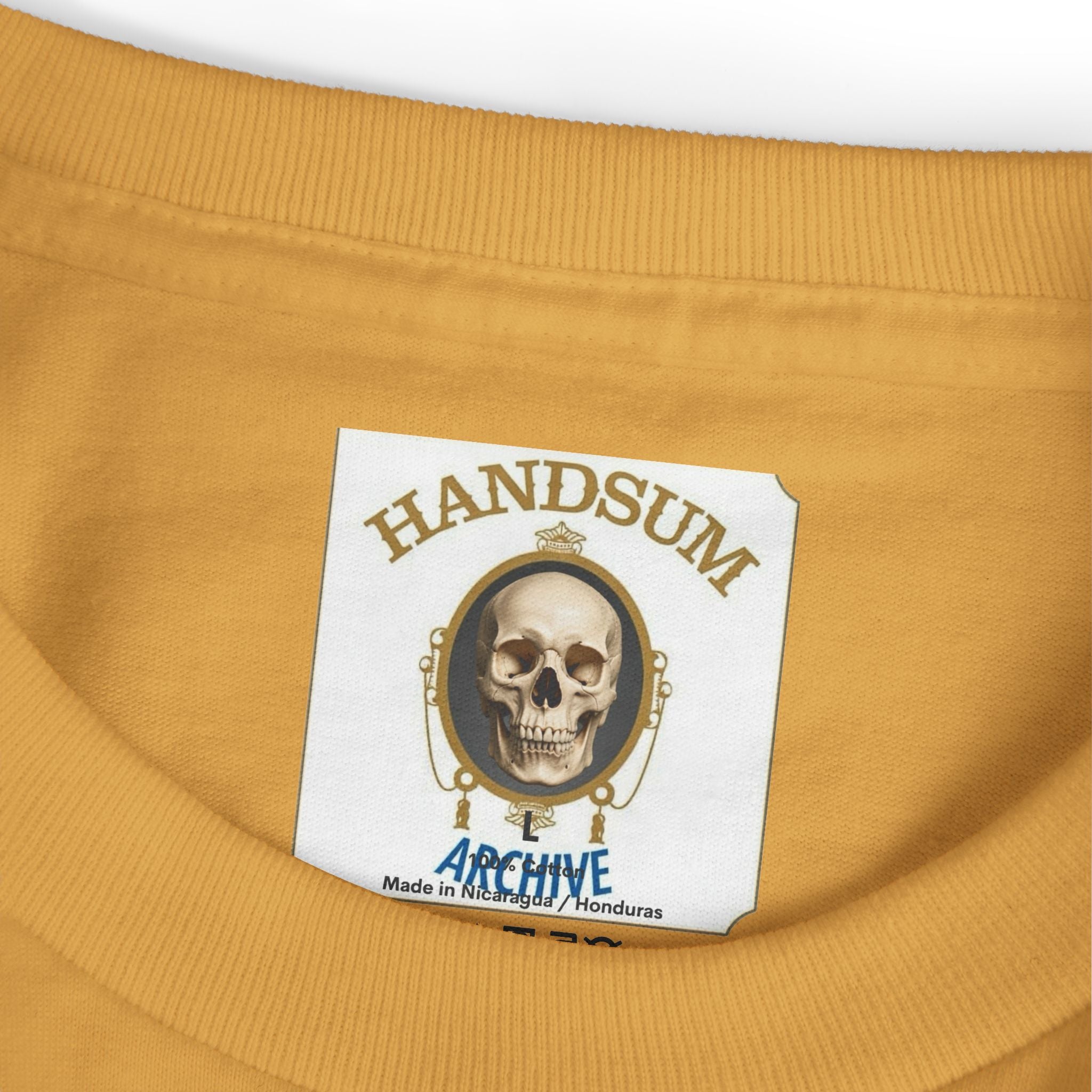 Faded mustard crewneck tee with skull logo patch graphic