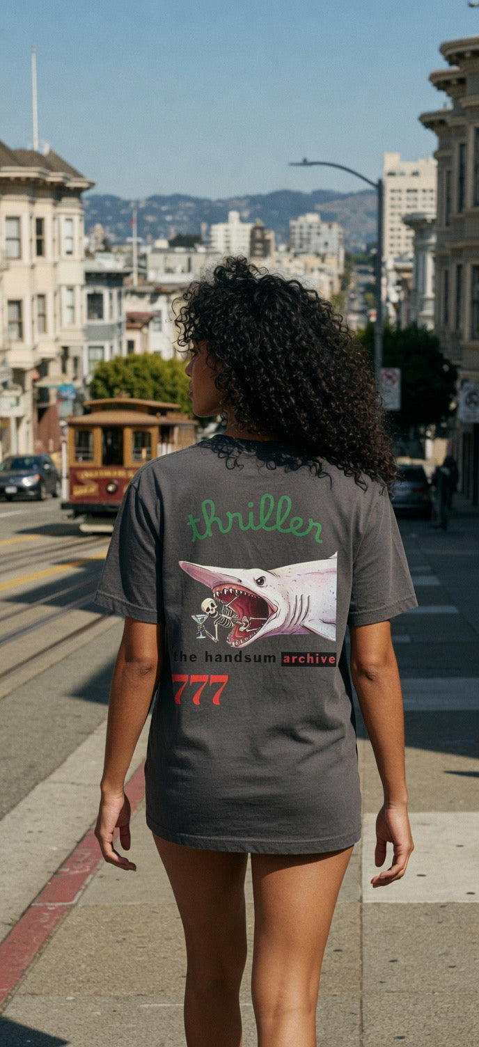 Dark crewneck tee with fish graphic and teal word 'triballer' on back