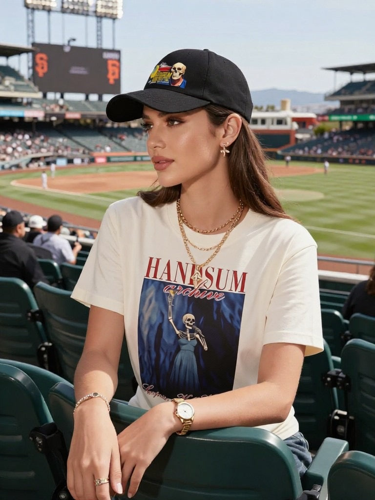 Black baseball cap worn by a woman with a skull graphic front