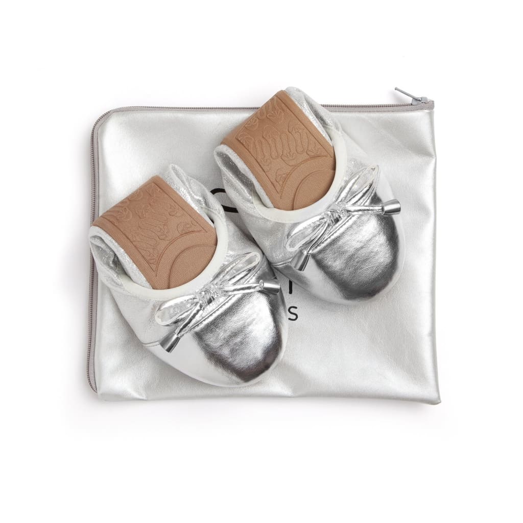 Pair of silver metallic flats with bow-tie accents and cushioned insole